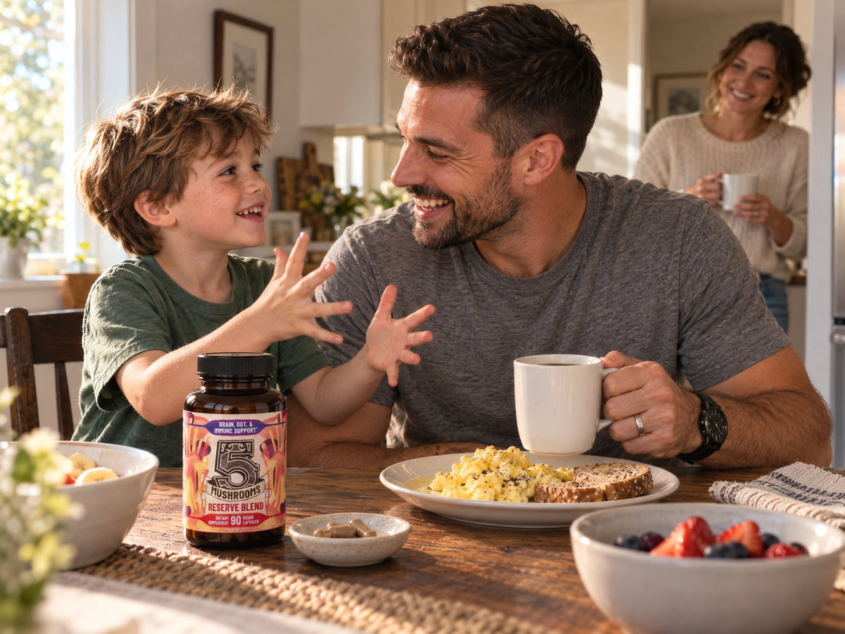 Dad laughing at breakfast with his son, a bottle of 5 Mushrooms Reserve Blend on the table
