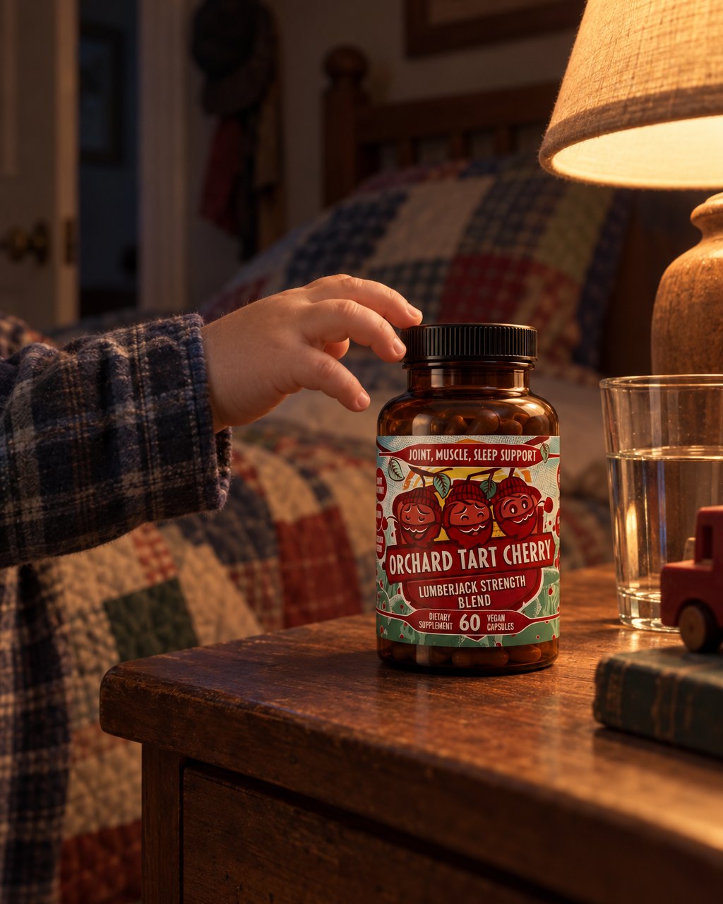 A bottle of Orchard Tart Cherry on a nightstand beside a glass of water and a lamp